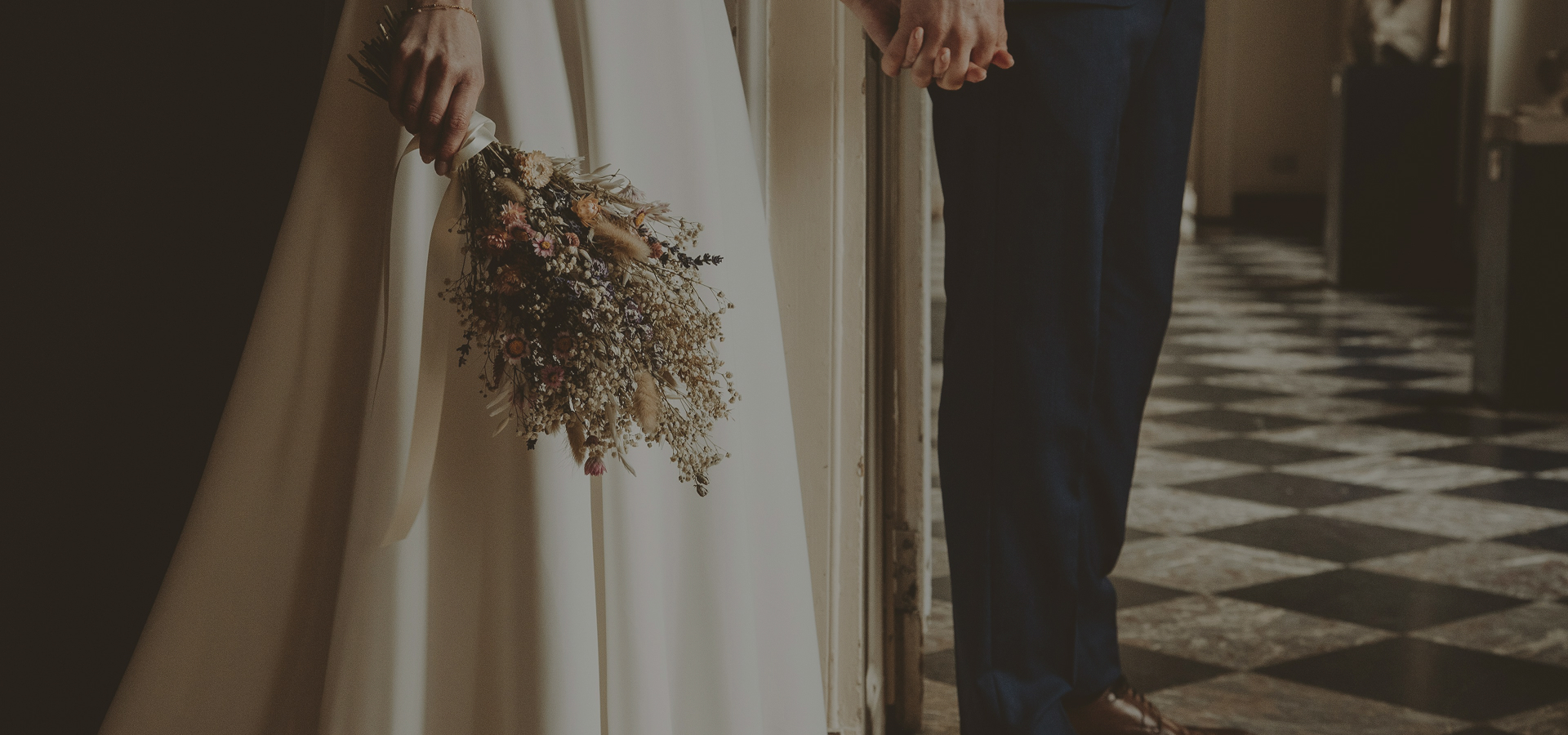 main visual - bride with flowers and groom holding hands