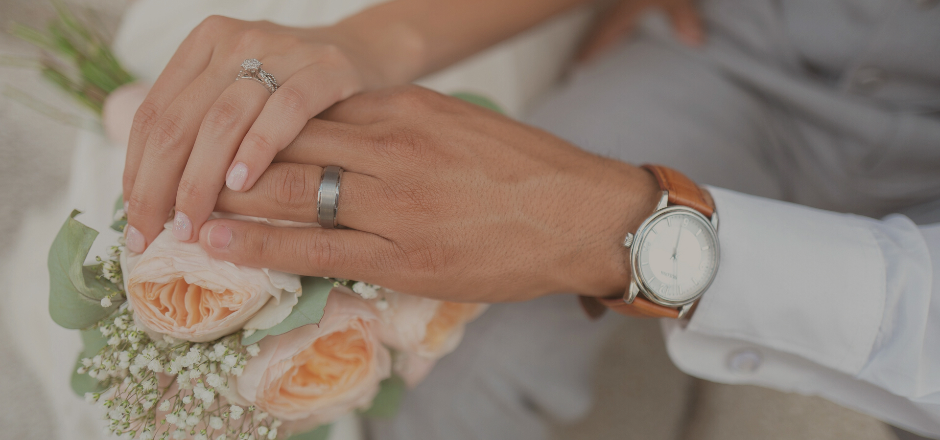 main visual - bride and groom's hands on the boquet